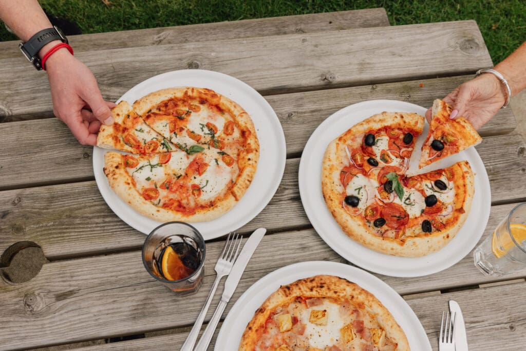 Wood-fired pizzas shared at an outdoor table during Pizza Nights at Willowgate Café near Perth