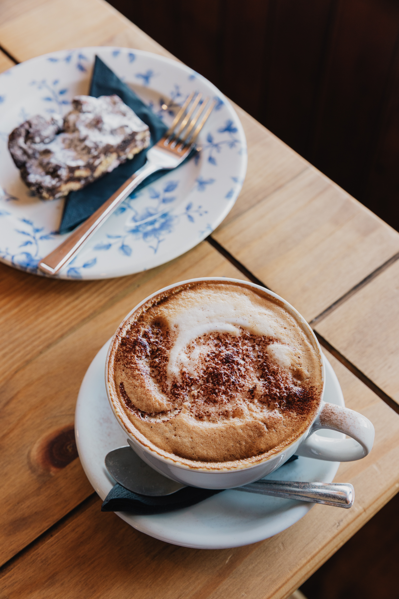 Cappuccino with latte art and a slice of homemade cake at Willowgate Café near Perth