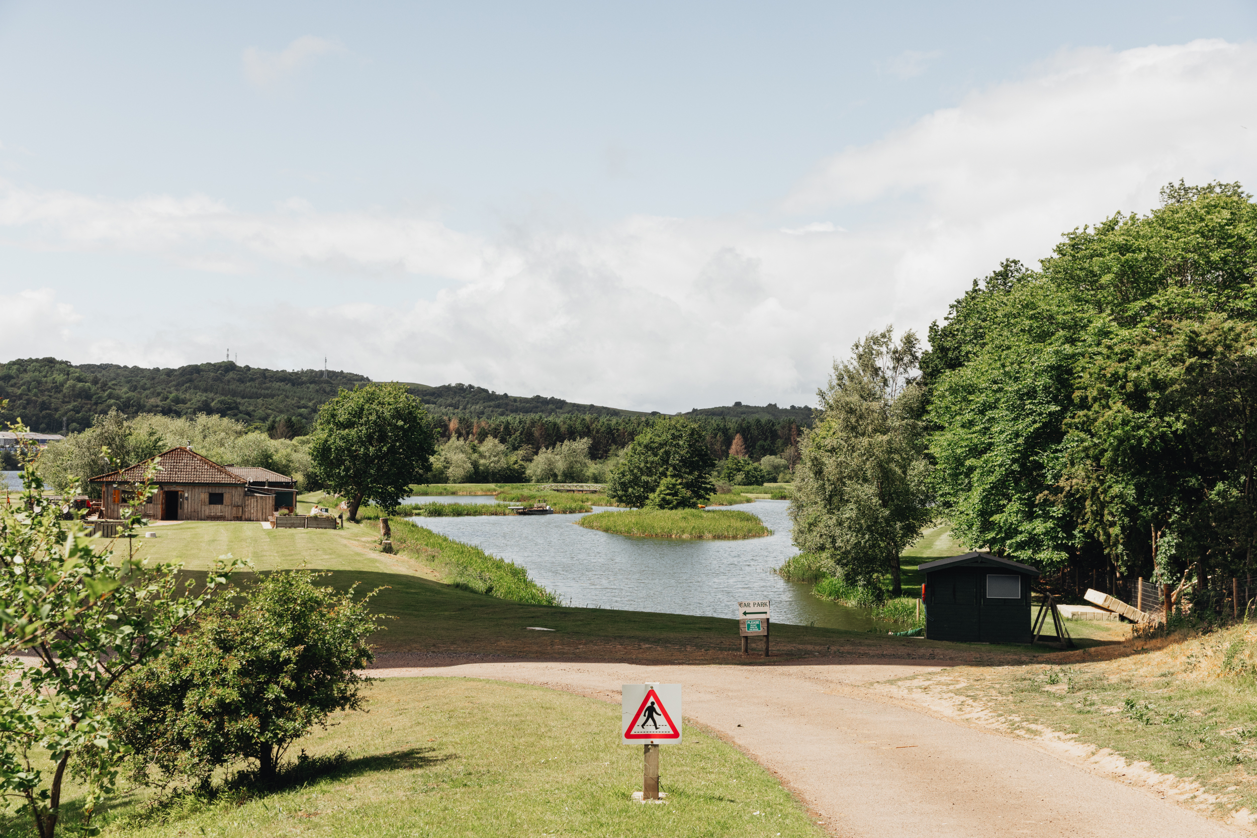 Willowgate Café's timber lodge overlooking the loch, with car park signage, near Perth